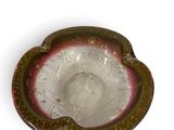 a glass ashtray with a red and white design on it