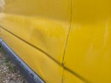 a yellow van that is parked on the side of the road