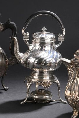 trois théières en argent et une théière en argent posée sur un support