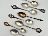 six cuillères en argent sont alignées sur une surface blanche
