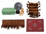 quatre tapis et une valise posés sur une surface blanche