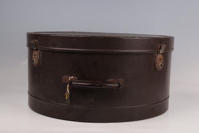 une valise marron posée sur une table blanche