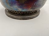 a large metal bowl with a metal base on a table