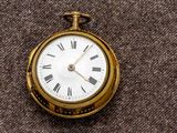 une montre de poche en or avec des chiffres romains