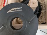 un objet noir dans une boîte en bois posée sur une table