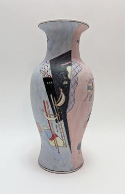 a vase with a painting on it sitting on a table