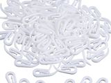 a close up of a pile of white plastic hooks on a white background