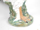 a white bird that is sitting on a green base