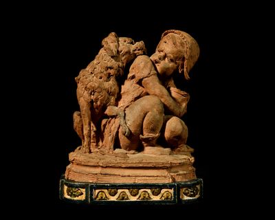 a statue of a child and two dogs on a pedestal