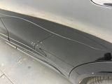 the rear end of a car with scratches on the side of it