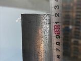 a measuring tape that is on the side of a metal pipe