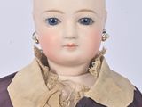 a doll that is wearing a purple dress and gold earrings