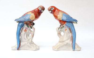 two figurines of parrots sitting on a tree branch