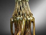 a gold vase that is sitting on a black table