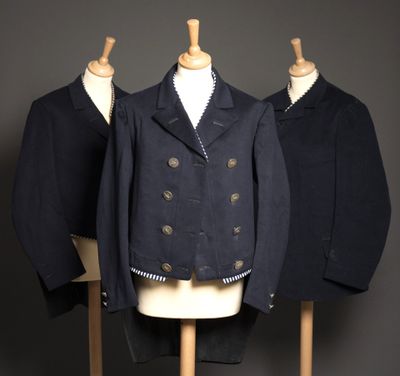trois manteaux posés sur un présentoir à mannequin sur lequel sont accrochées deux vestes