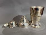 a silver cup and two silver cups on a table