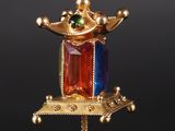 une image représentant un collier en or surmonté d'une couronne
