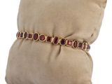 beige pillow with a cushion and a gold bracelet on it
