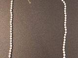 gros plan d'un collier de perles sur une surface noire