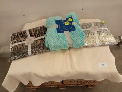 un lit sur lequel sont posés une couverture et une paire de mitaines