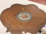 a small wooden table with a decorative plate on top of it