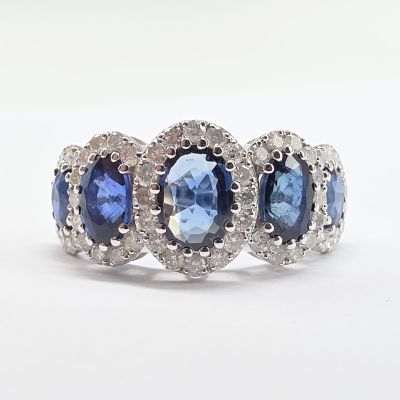 une photo d'une bague à trois pierres, avec des pierres bleues et blanches