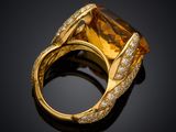 a gold ring with a large citrine stone surrounded by diamonds