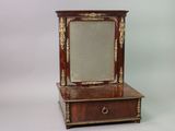 a small mirror sitting on top of a wooden dresser