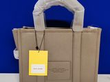 a beige handbag with a yellow tag on it