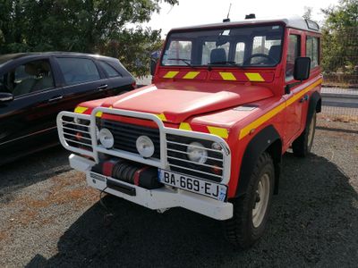 un camion de pompiers rouge et jaune garé à côté d'une voiture noire