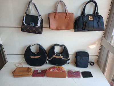 Plusieurs sacs à main et sacs à bandoulière sont exposés sur une table blanche