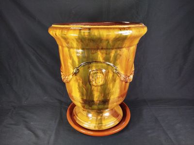 a yellow vase that is sitting on a wooden stand
