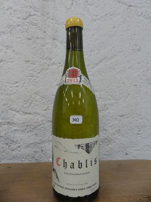 une bouteille de vin posée sur une table, avec un mur blanc en arrière-plan