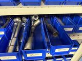 many blue bins with different types of pipes in them