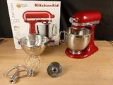 a red kitchen aid mixer and a box on a table