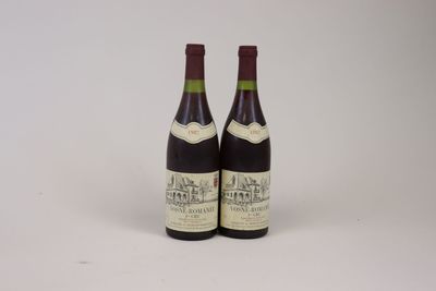 two bottles of wine sitting next to each other on a white surface