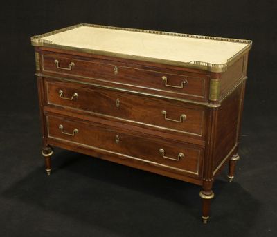 an antique chest of drawers with marble top and brass trim