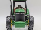 a toy tractor that is sitting on a white surface