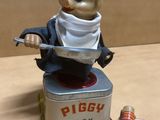 a figurine of a piggy cook sitting on a tin