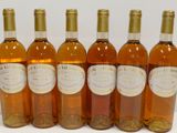 six bottles of wine are lined up in a row on a table