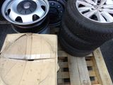 tires and rims are stacked on pallets in a parking lot