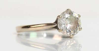 gros plan d'une bague en diamant sur une surface blanche