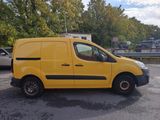 the yellow van is parked in the parking lot near the trees