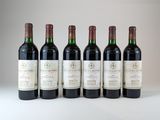 six bouteilles de vin sont alignées sur une surface blanche