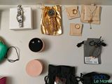 many items on the wall of a room that includes a purse, a watch, and other items
