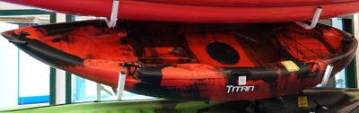 Plusieurs kayaks sont empilés les uns sur les autres dans un local de stockage