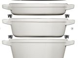 three white pots and pans stacked on top of each other