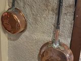 pots and pans hanging on a wall in a kitchen