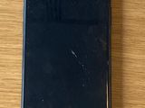 an iphone with a cracked screen sitting on top of a wooden table