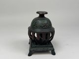 an antique bronze incense burner with a green patt finish